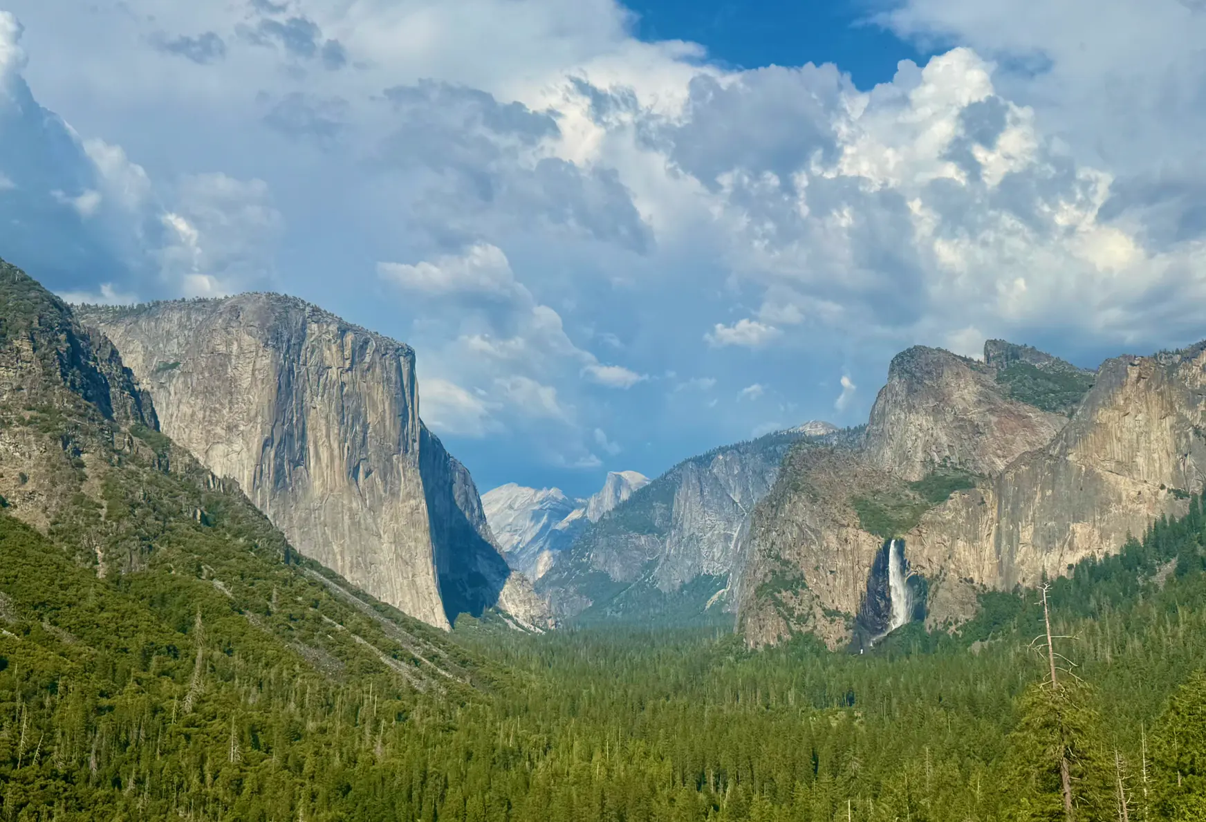 <p>Tunnel View，左边是 El Capitan 酋长岩，中间隐约能看到 Half Dome，右边是 Bridalveil Fall</p>
